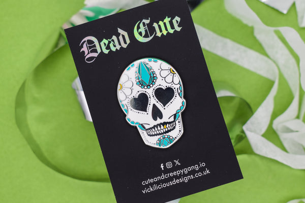 Decorative sugar skull pin on a 'Dead Cute' card with a green background